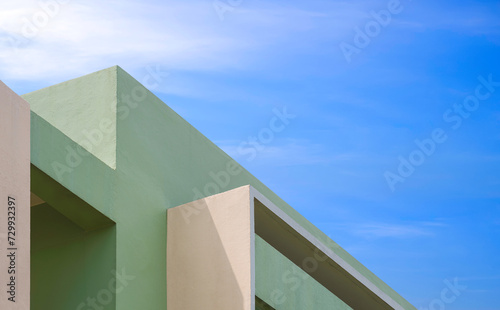 Modern green and beige house building with geometric pattern of shading fins concrete on exterior wall against blue sky, Low angle and perspective side view, Abstract minimal architecture background