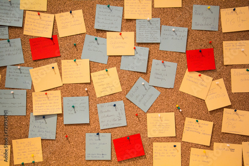 Photo of different colorful memo papers attached with pins to the wooden board. High quality photo photo