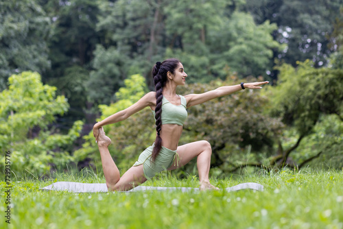 Indian woman practices yoga in park setting, fitness and wellness concept