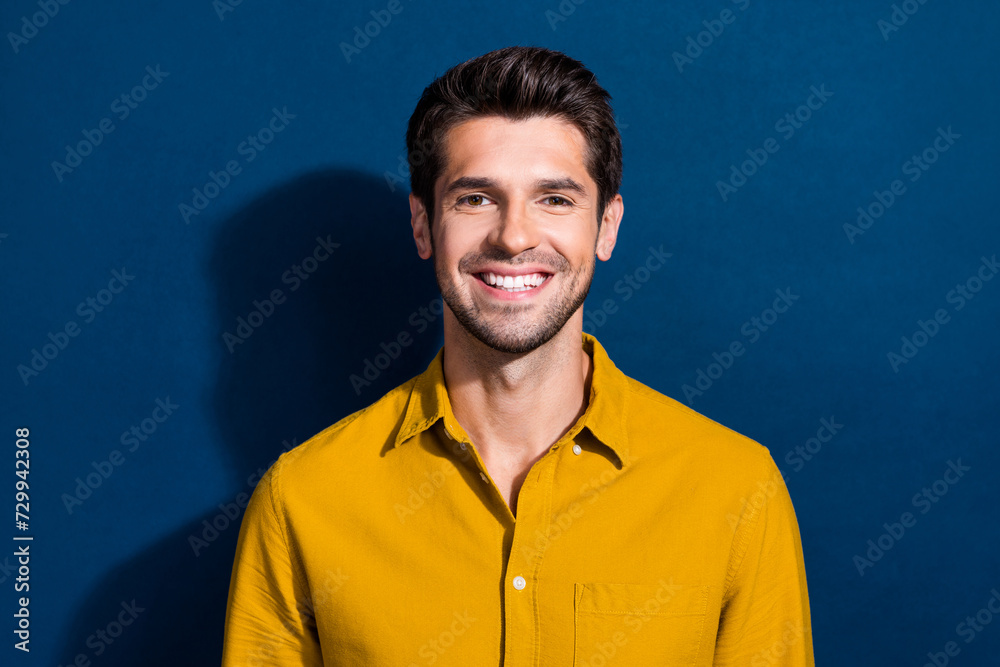 Photo portrait of handsome young guy cheerful toothy smile wear trendy yellow outfit isolated on dark blue color background Photo portrait of handsome young guy cheerful toothy smile wear trendy yellow outfit isolated on dark blue color background