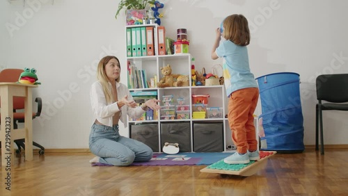 A joyful lesson in speech: child and therapist, games, letters, learning. Happy office vibes, education and fun together.