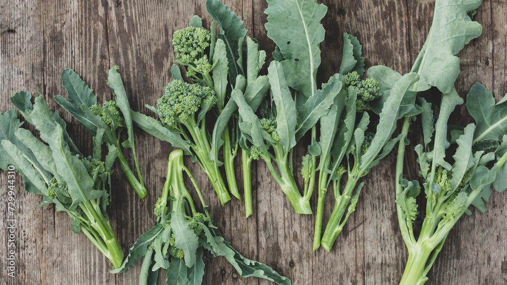 Young broccoli inflorescences on a wooden background. Top view. Young broccoli inflorescences on a wooden background. Top view.