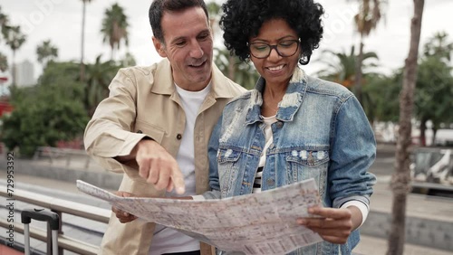 Tourists checking city map looking for landmark or hotel destination - African American traveler couple photo