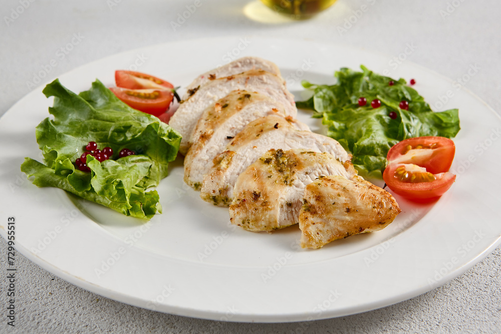 Grilled chicken breast with vibrant salad garnish on a minimalistic white setup, perfect for clean eating and diet concepts