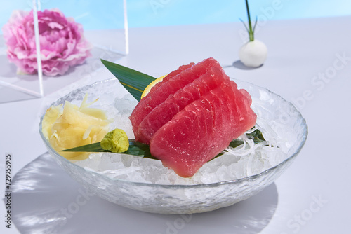 Tuna sashimi displayed on crushed ice, accented with surreal spring and summer flowers, a refreshing culinary delight