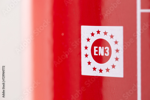 closeup of a marking on a fire extinguisher that complies with european norm regulation as a safety device to prevent blaze and fire hazards