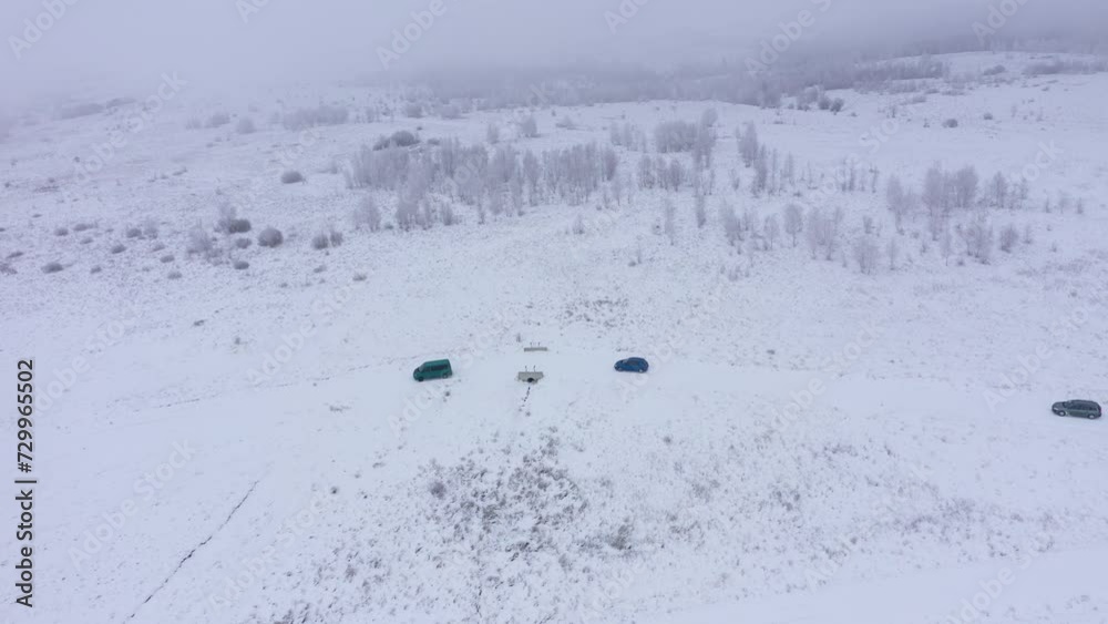 Aerial view of a cars driving on a winter road in misty, foggy winter weather Aerial view of a cars driving on a winter road in misty, foggy winter weather