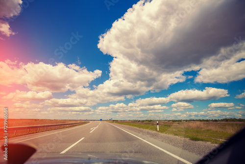Highway with cloudy sky in summer. View of the road through the windscreen © vvvita