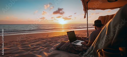 A digital nomad in the sands of a beach with a notebook working in the sunset, sitting close to the shoreline, sun, sky, horizon, ocean waves and seascape in the background. AI generated image.