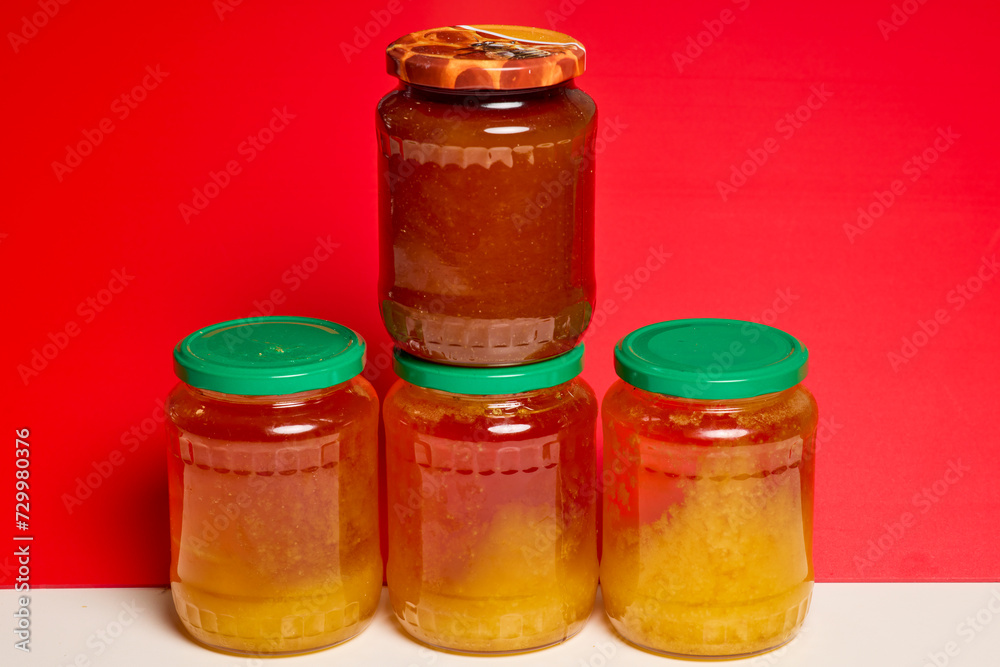 Jar of natural honey made at home on a table. Jar of natural honey made at home on a table.