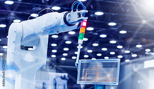 Industrial arm manipulator. Modern robot for production. Hand manipulator near monitor with data. Programmable robot for manufacturing. White hand manipulator in factory. Robotization production