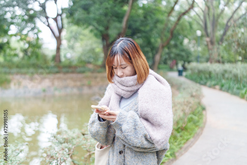 冬の寒い香港尖沙咀の公園で過ごす20代の中国人女性 A Chinese woman in her 20s spending time in a park in Tsim Sha Tsui, Hong Kong, which is cold in winter photo