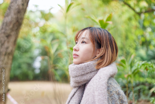 冬の寒い香港尖沙咀の公園で過ごす20代の中国人女性 A Chinese woman in her 20s spending time in a park in Tsim Sha Tsui, Hong Kong, which is cold in winter photo