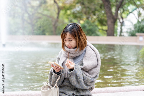 冬の寒い香港尖沙咀の公園で過ごす20代の中国人女性 A Chinese woman in her 20s spending time in a park in Tsim Sha Tsui, Hong Kong, which is cold in winter photo