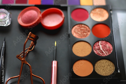 Various colorful make up products on dark background. Selective focus.