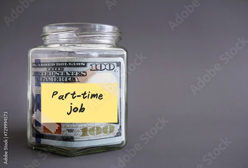 Money glass jar bottle filled with cash dollars money with label PART-TIME JOB, concept of make more income by side job, second gig or side hustle in spare time after work hours