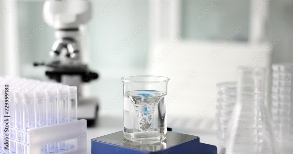 Transparent liquid water in glass flask and magnetic water purification. Magnetic water treatment