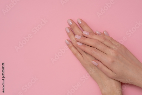 Natural manicure on pink background.