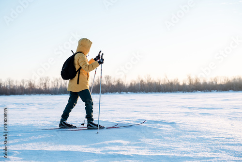 Man on skis walking on snow in winter on the background of the forest, training in the fresh air, winter walk in nature.