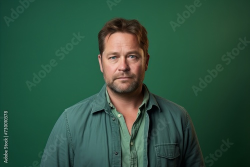 Portrait of a man in a green shirt on a green background