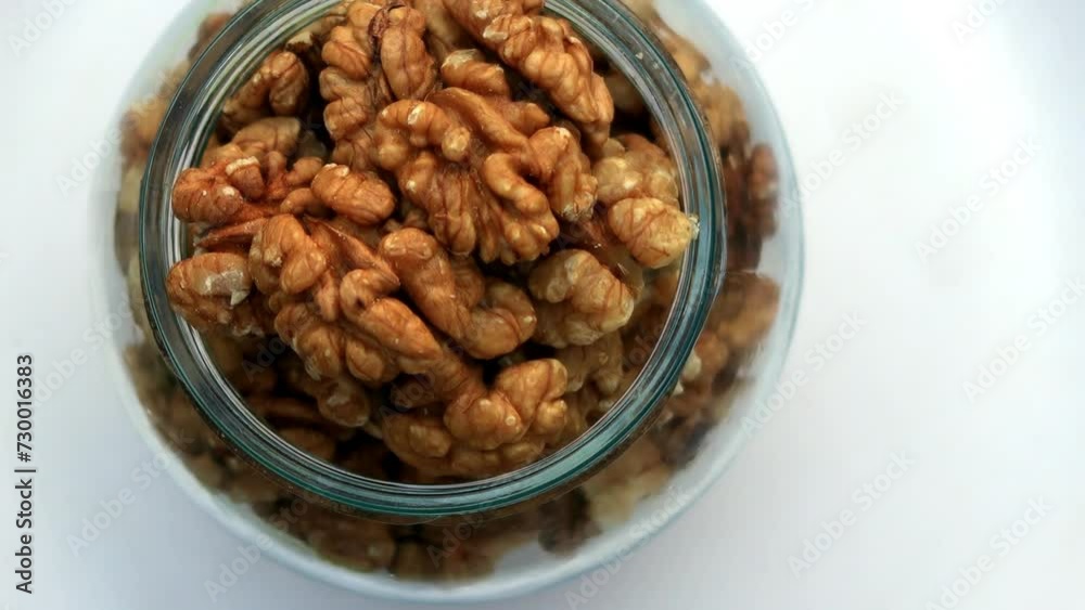 Walnuts in glass bowl table top spin isolated on white background. Walnuts in glass bowl table top spin isolated on white background.