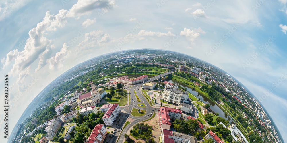 Aerial view from high altitude tiny planet in sky with clouds overlooking old town, urban development, buildings and crossroads. Transformation of spherical 360 panorama in abstract aerial view. - obrazy, fototapety, plakaty 