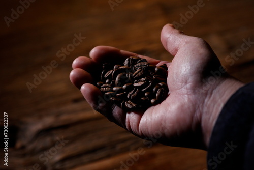 コーヒー豆を掬う男性の手