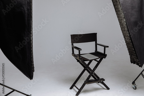 Director's chair in photo studio with laptop and flashes