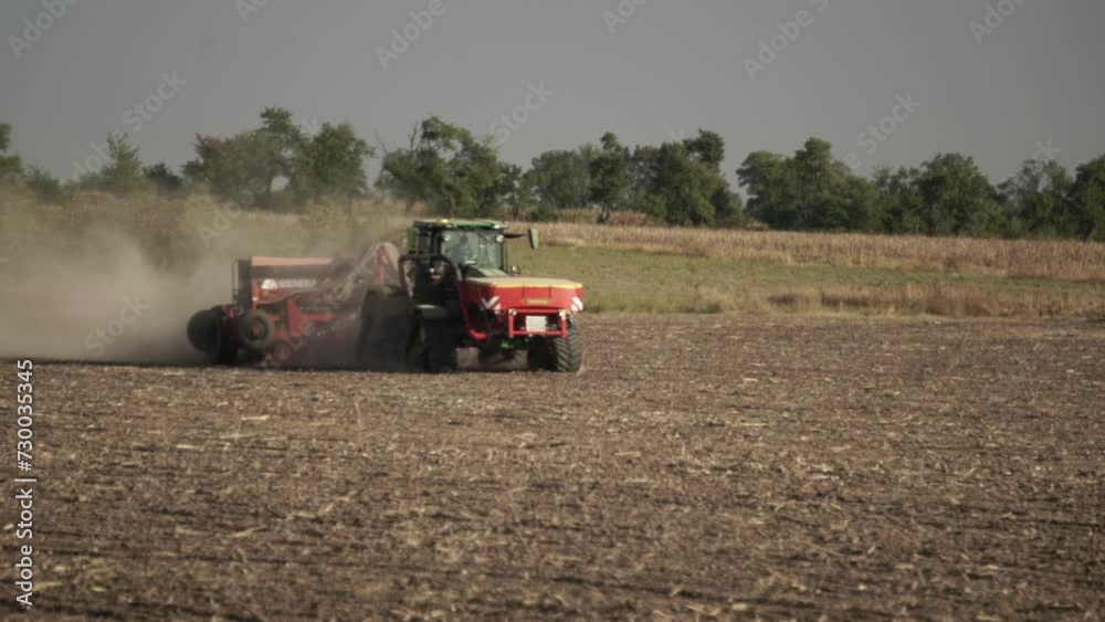 Green tractor seeding wheat on the field Green tractor seeding wheat on the field