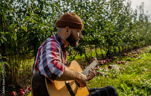 Man 's hand playing acoustic guitar, song. Nature background. Guitars acoustic. Male musician playing guitar, music instrument. Man's hands playing acoustic guitar photo