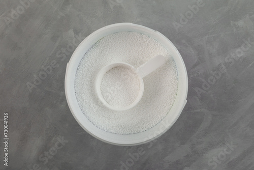 Sodium percarbonate powder or sodium carbonate peroxide in plastic box. Oxidizing agent SPC is an ingredient in number of home and laundry cleaning products, including non-chlorine bleach products photo