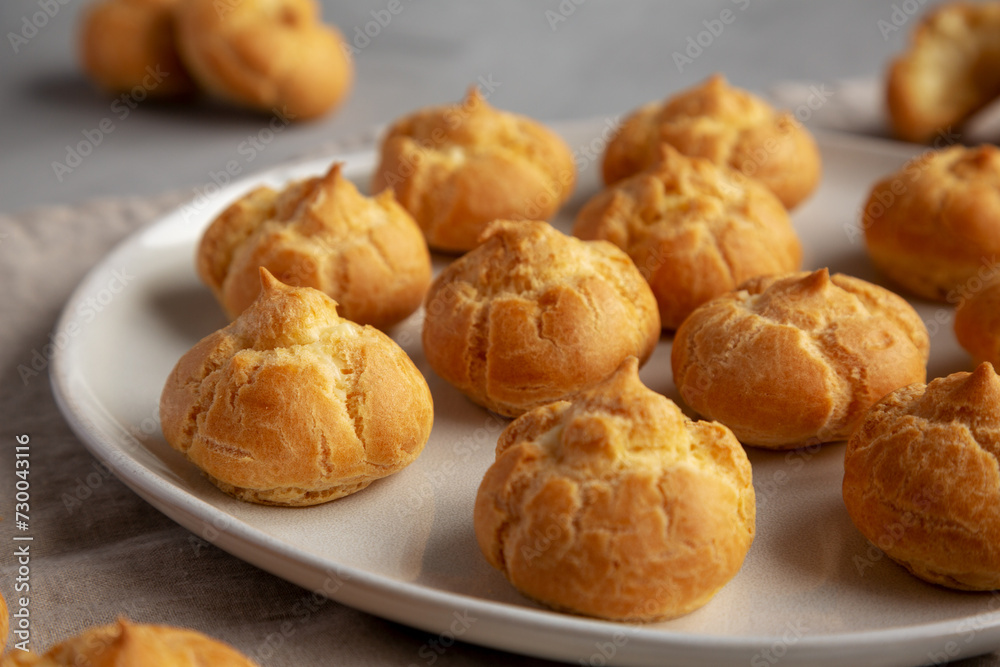 Homemade Mini Cream Puffs on a Plate, low angle view. Close-up. Homemade Mini Cream Puffs on a Plate, low angle view. Close-up.