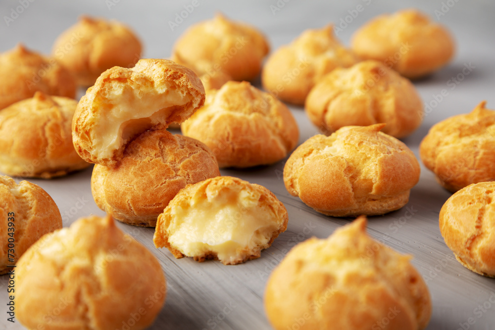 Homemade Mini Cream Puffs on a gray background, low angle view.