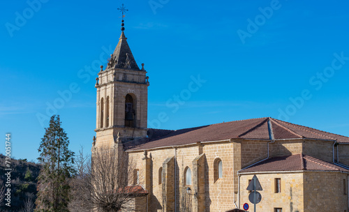 catholic stone church with bell tower and blue sky