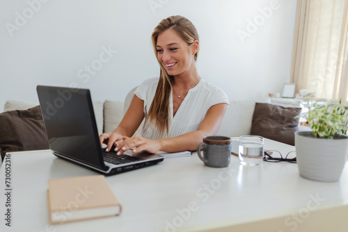 Elegant, professional and freelance worker on her laptop inside home office. Formal, stylish and fashionable corporate employee online. Remote, communication and sending emails in digital workplace.