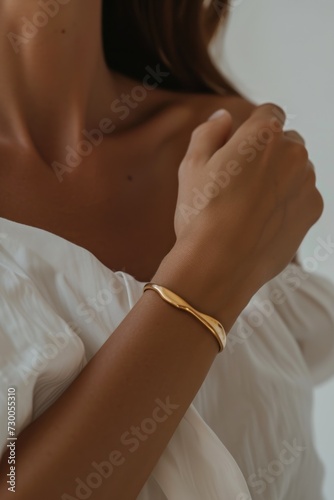 Thick gold bracelet on a woman's wrist. Quiet luxury concept. 