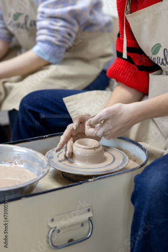 The student forms her first cup on the potter's wheel