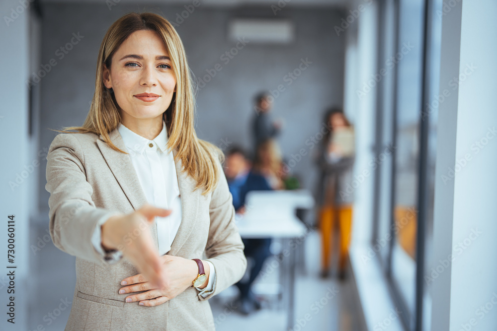Fototapeta premium Businesswoman Offering Handshake, woman stretching out hand for shaking hello gesture, feeling satisfied welcoming new client or getting acquainted indoors.