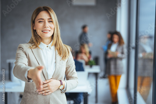 Welcome! Portrait of friendly hospitable cheerful woman giving hand to handshake, hostess greeting guest. Happy office employee giving hand for shaking