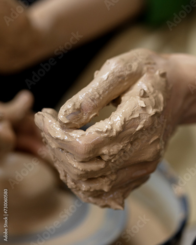 One woman's hand in clay after starting work on a potter's wheel. Close-up