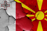 flags of Malta and North Macedonia painted on cracked wall
