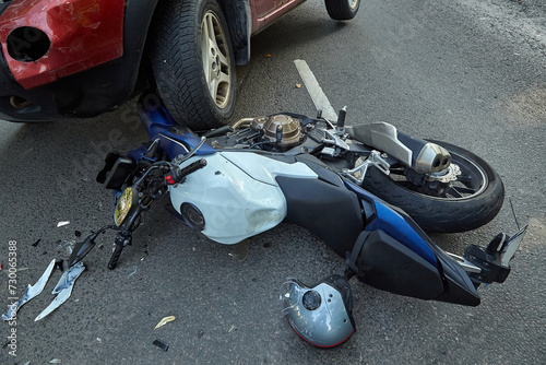Damaged motobike and  a car in a accident photo