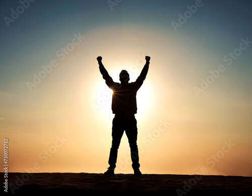Silhouette of a person with both arms raised in victory. Concepts of success and achievement.