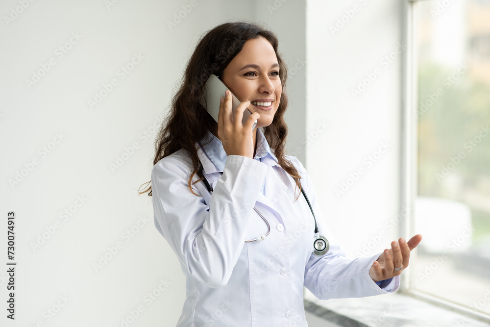 Friendly young woman doctor have remote consultation, talking on phone Friendly young woman doctor have remote consultation, talking on phone