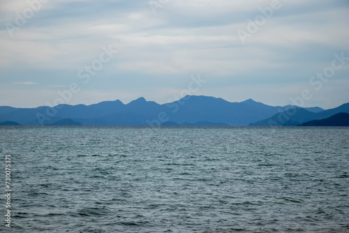 wide landscape of sea blue sky and mountains