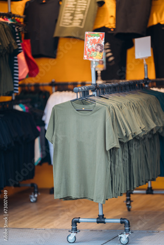 Simple and stylish green t-shirts displayed in a minimalist fashion store in Bangkok.
