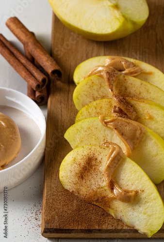 Green apple with cinnamon and peanut butter. A delicious and healthy dessert.