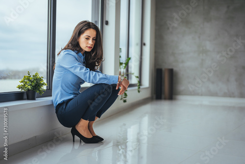 One Desperate stressed businesswoman sitting on the floor. The woman was stressed and disappointed by being fired. Concept of layoffs and unemployment.