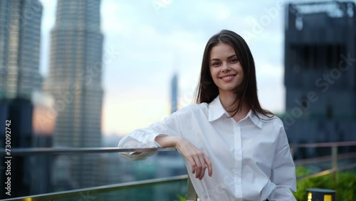 Young woman portrait looking into the camera with a smile on the street in the background of the city