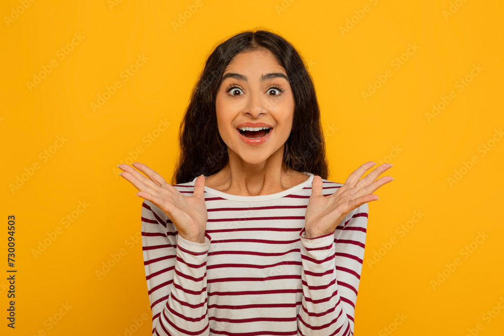 Surprised young indian woman gesturing on yellow background Surprised young indian woman gesturing on yellow background
